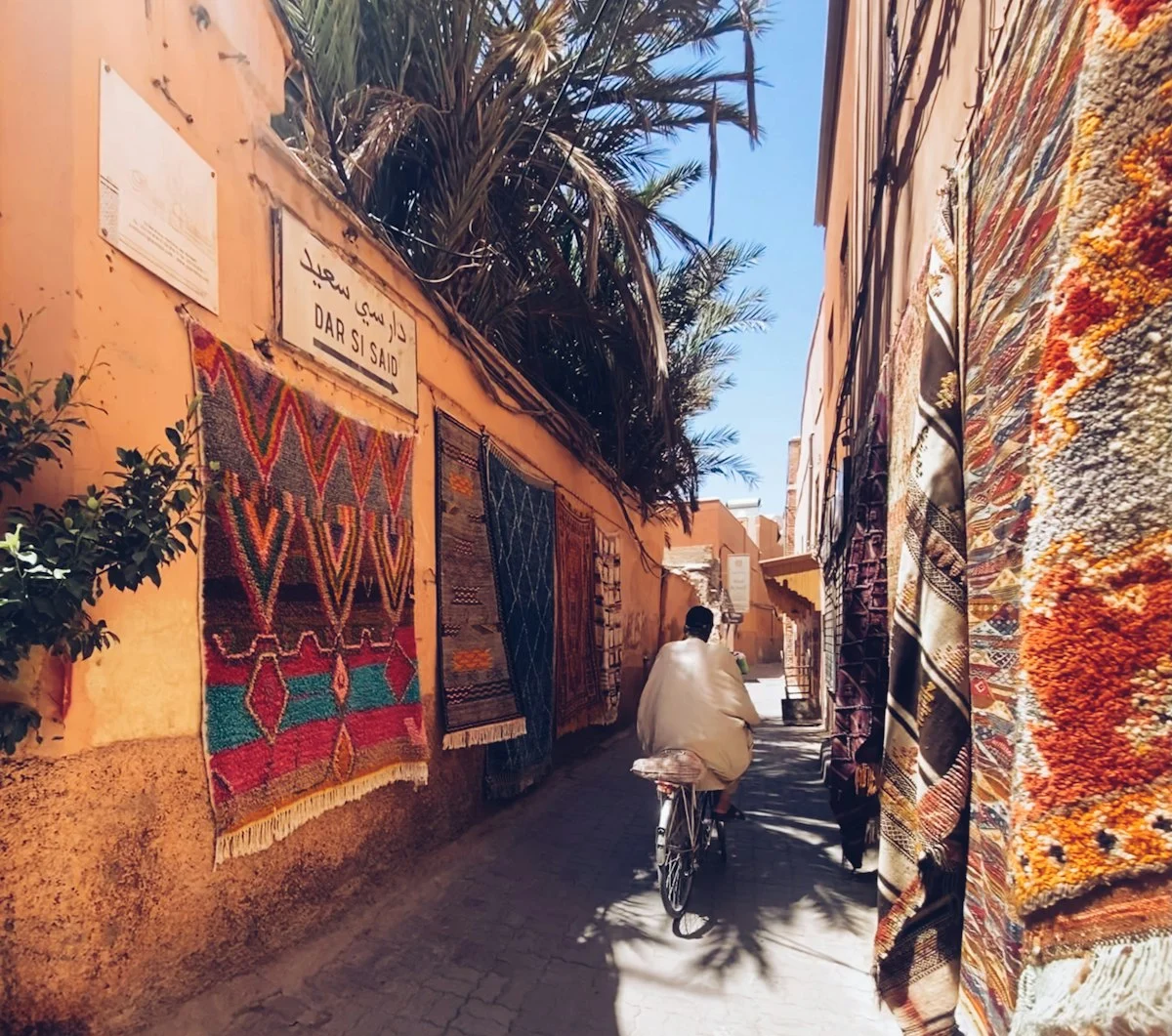 a man riding a bike down a narrow street