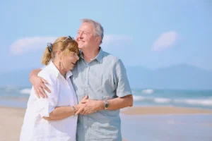 Elderly couple embracing on a sunny beach