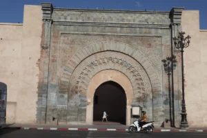 Ornate archway entrance with a person and scooter.